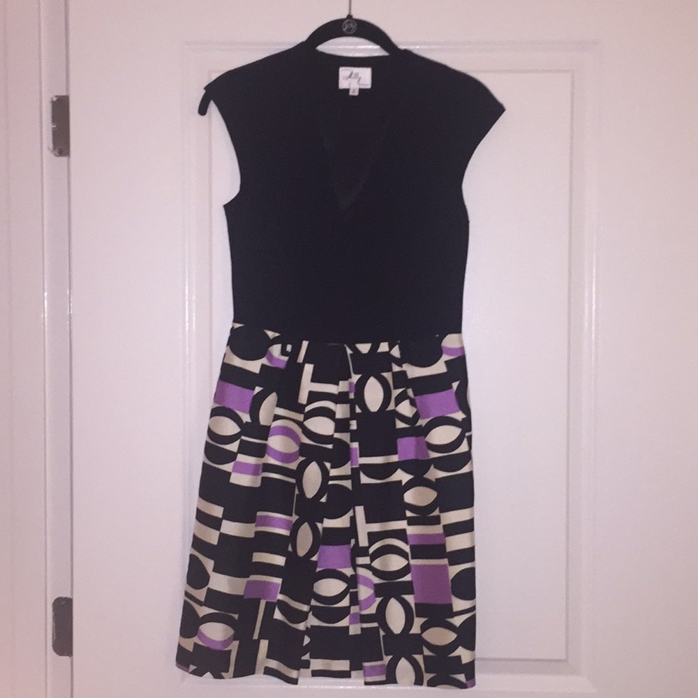 Low cut front. Pleated skirt w/black belt.